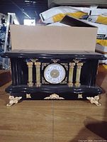 front view showing dial, columns, gold toe feet and trim