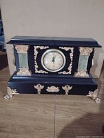 Front view of mantel clock showing dial and gold accents