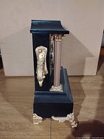 Left side profile showing depth and gold-tone side scroll and feet