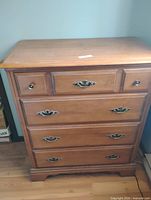 Front view of maple dresser showing drawer arrangement and hardware