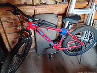 Full view of red and blue Hiland bicycle showing frame design, front suspension and overall condition