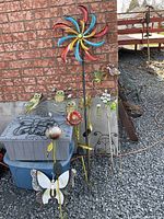 Group shot of wind spinner, stakes, tote bins, brick wall background
