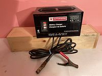 Front view of Motomaster battery charger with cords and clamps visible