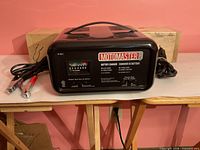 Front view showing MotoMaster branding, meter, clamps and overall condition