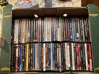 Open box showing two rows of assorted music DVD cases