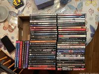 Stacked DVD cases and disc contents displayed on table