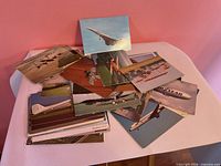 Pile of assorted airplane postcards on table
