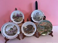 All five cottage scene plates on stands