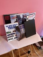 Group of eight train books standing on table