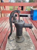 Full side view of cast iron pump showing handle and spout