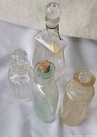 Four bottles standing with stoppers visible