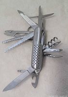 Multi-tool fully unfolded showing assortment of fifteen stainless tools