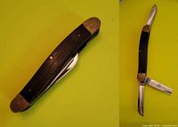 Knife closed showing wood scales and brass bolsters