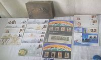 Overall lot showing brass tin, UK stamp booklets, CFL and Queen Elizabeth envelopes