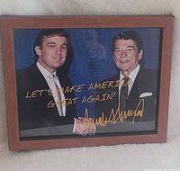 Front view showing Trump and Reagan handshake photograph with gold text and signature in brown frame