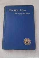 Front cover showing title, blue cloth and gilt crest