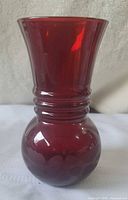 Full view of ruby red glass vase showing shape and color