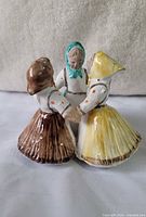 front view showing three dancers holding hands