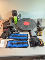 Overview of lot showing dumbbells, balance board, foam rollers, ankle weights, wrist weights, gloves