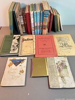 Front view showing all 23 books upright and spread, mix of formats and titles