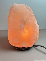 Front view of illuminated salt lamp showing color and shape