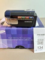 Samsung camcorder on original box showing 65x Intelli-Zoom label