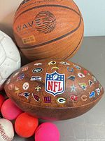 Basketball, football, white ball and five small balls grouped together