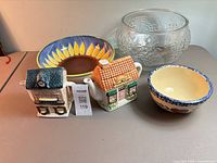 Group view showing both cottage teapots, sunflower pasta bowl, clear textured glass bowl, and cream bowl