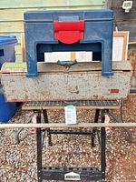Blue plastic toolbox on top of Union metal toolbox placed on Jobmate workbench with yardstick in front