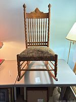 Full front view of oak spindle back rocking chair on table