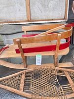 Overall view of wooden sled and damaged snowshoe