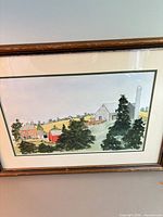 Framed watercolor painting of farm scene with barns, silo, trees; shows matting and wooden frame