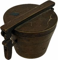 closed brass container showing handle and patina