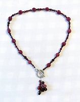 Entire necklace laid flat showing bead pattern, clasp and pendant cluster