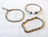 All three silver-tone bracelets laid out