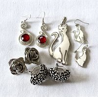 Group shot of pendant and four pairs of earrings on white background