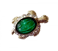 Front view showing green glass cabochon shell and rhinestone border
