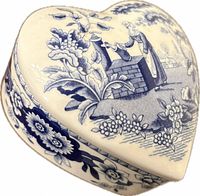 Top view of heart-shaped trinket box showing Girl at the Well scene and floral decoration