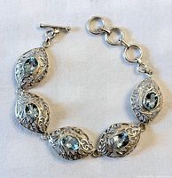 Full view of sterling silver bracelet showing five navette links and toggle clasp