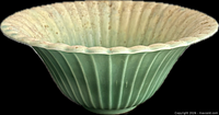 Side view of green ribbed Beswick Ware pottery bowl with scalloped rim