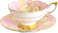 Teacup on saucer, showing pink glaze and gold decoration
