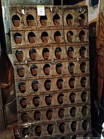 Full view of wooden bottle rack showing grid of oval cutouts