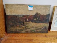 Front view of unframed oil landscape painting leaning against wall