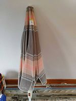 Folded striped patio umbrella full view