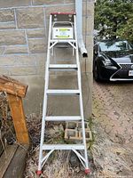Full view of aluminum A-frame ladder leaning against wall showing five rungs and top platform