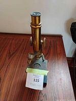 Front view of brass microscope showing full height and base