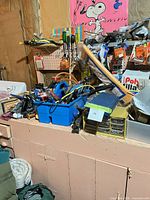 Workbench with screwdrivers, pliers, hacksaw, blue tote, small parts organizer