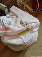 Bag holding folded white and ivory linens