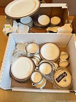 two boxes containing assorted Aynsley bone china plates, bowls, cups and platter