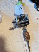 Close view of reel, rod handle, tangled line, wood grip wear